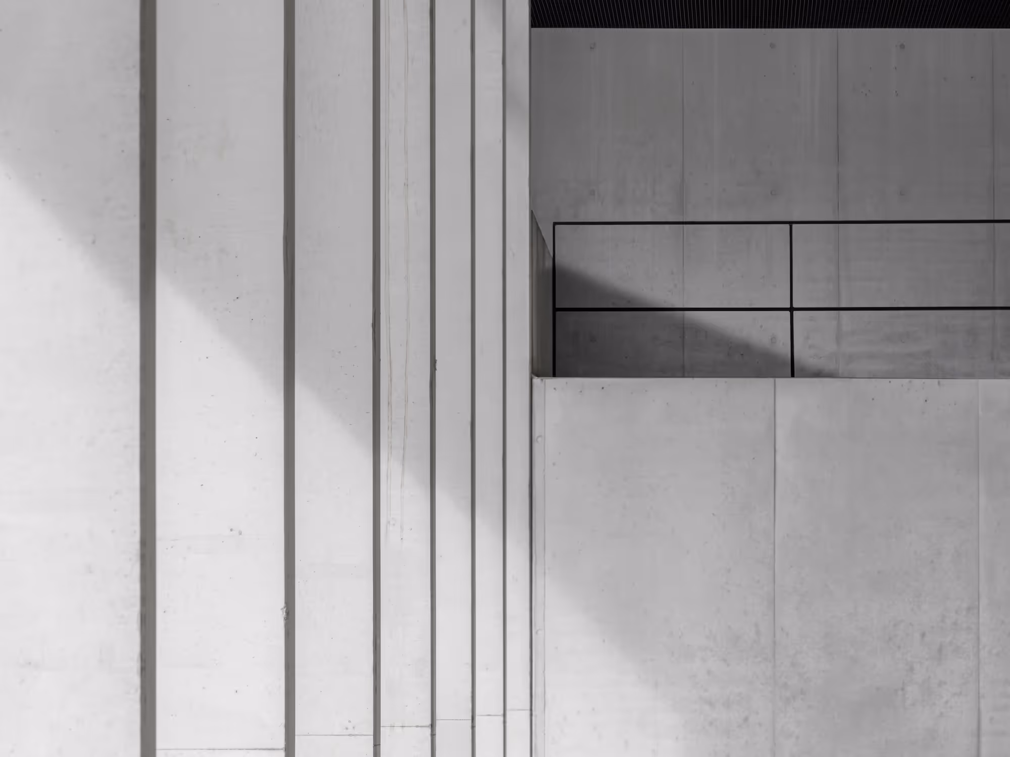 Abstrakte Ansicht von hellen Betonwänden mit vertikalen Linien und Schatten.