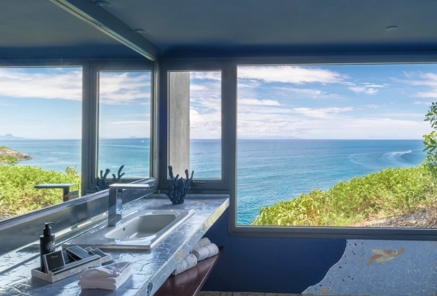 Salle de bain de la Suite Panoramique à La Toubana Hôtel & Spa, avec large vue sur l’océan turquoise.