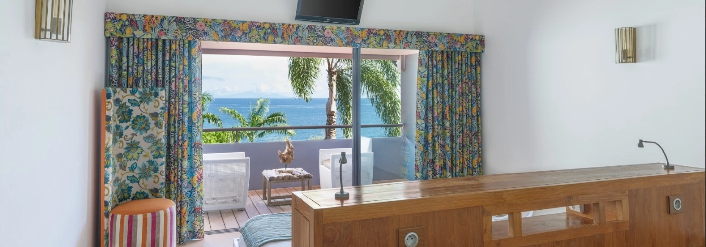 Chambre de la Suite Classique à La Toubana Hôtel & Spa, avec grand lit et vue sur la mer.