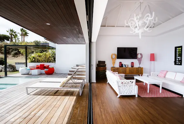 Salon lumineux d’une villa de luxe à La Toubana Hôtel & Spa, avec terrasse, piscine et vue sur la mer en Guadeloupe.