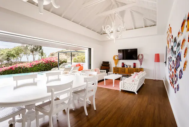 Chambre de villa de luxe à La Toubana Hôtel & Spa, avec lit à baldaquin, balcon, piscine et vue mer en Guadeloupe.