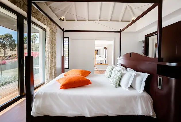 Chambre de luxe avec lit à baldaquin à La Toubana Hôtel & Spa, location de villa en Guadeloupe.