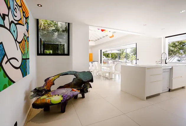 Intérieur moderne d’une villa de luxe à La Toubana Hôtel & Spa, avec salon coloré et cuisine ouverte en Guadeloupe.