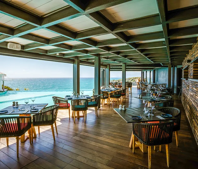 Terrasse du restaurant de La Toubana Hôtel & Spa, cuisine créole avec vue sur la mer et piscine à débordement en Guadeloupe.