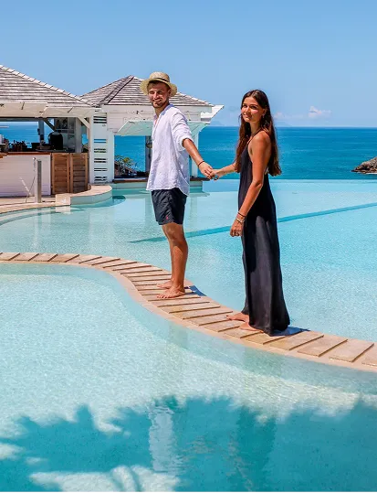 Couple se promenant au bord de la piscine à débordement avec vue mer à La Toubana Hôtel & Spa en Guadeloupe
