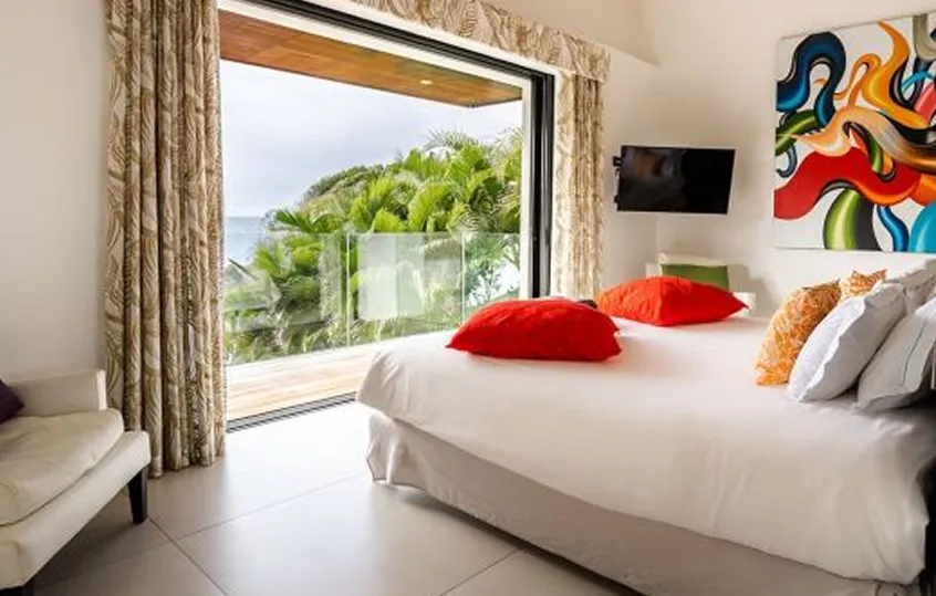 Luxury room at La Toubana Hotel & Spa, overlooking the sea and tropical vegetation in Guadeloupe.