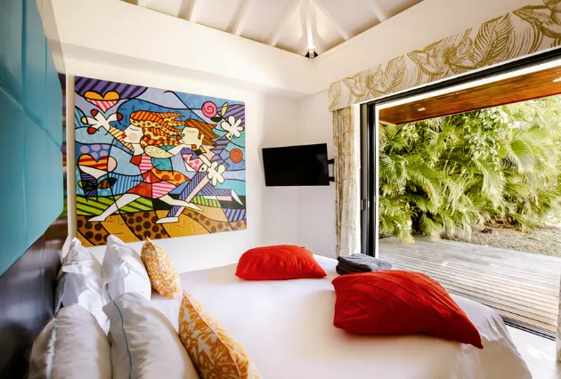 Salle à manger et salon d’une villa de luxe à La Toubana Hôtel & Spa, avec piscine et vue sur la végétation en Guadeloupe.