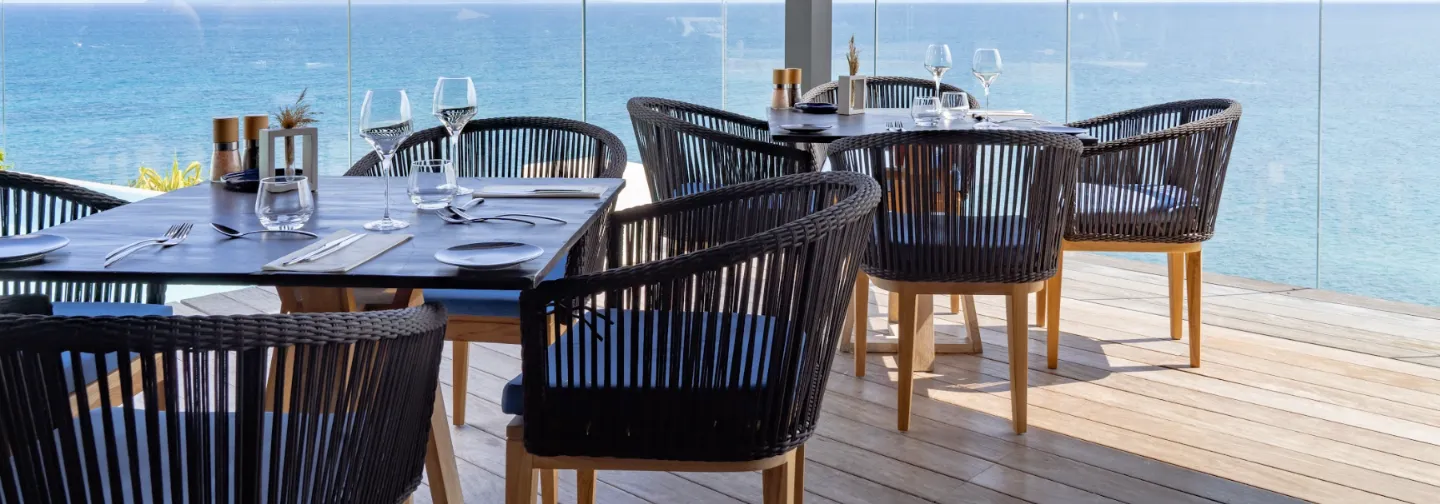 Tables dressées au restaurant Le Grand Bleu de La Toubana Hôtel & Spa, en bord de mer à Sainte-Anne.