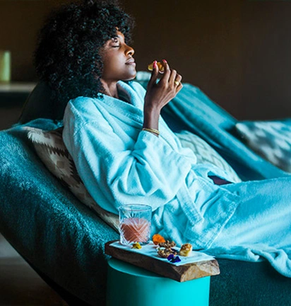 Woman in a bathrobe enjoying a moment of relaxation at the spa of La Toubana Hotel & Spa with drink and sweets.