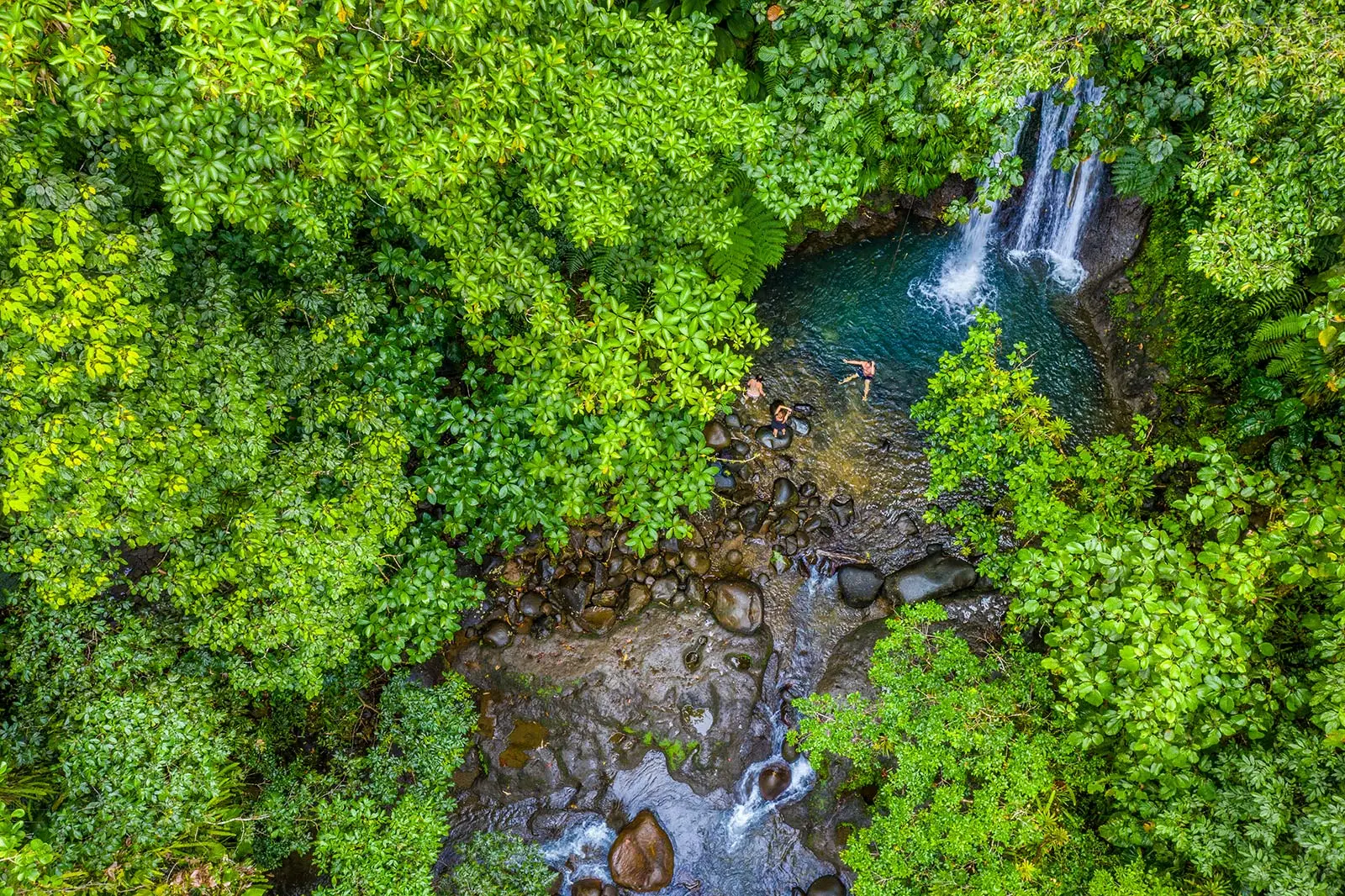 Cascade aux Écrevisses en Guadeloupe vue du ciel, bassin naturel entouré de forêt tropicale et baigneurs