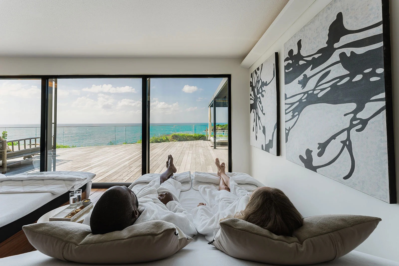 Couple en peignoir se relaxant dans une salle de repos du spa La Toubana face à la mer des Caraïbes