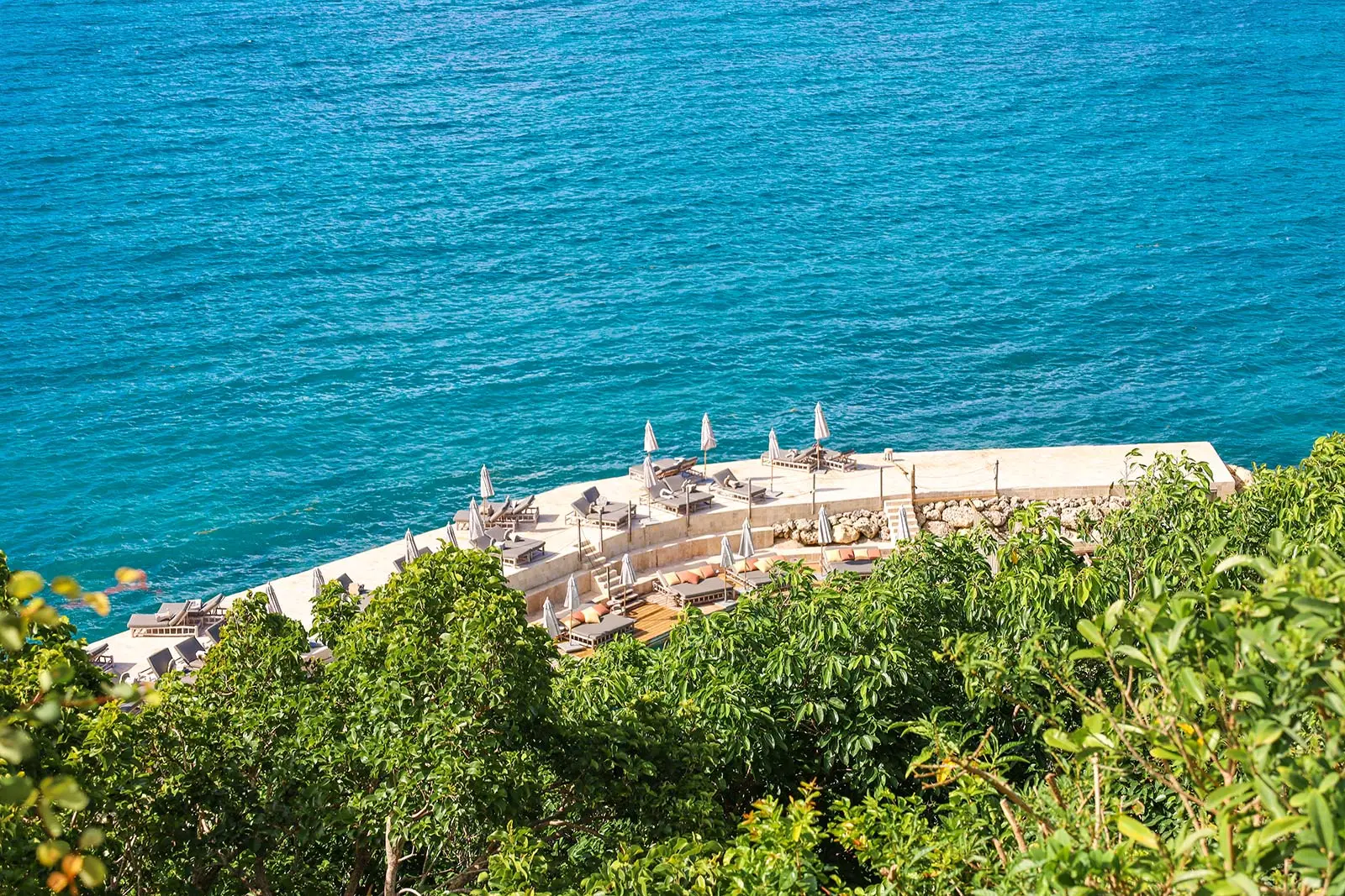 Solarium en bord de mer à La Toubana Hôtel & Spa, avec transats et vue panoramique sur l’océan en Guadeloupe