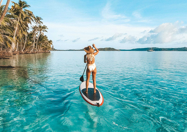 Femme faisant du paddle sur une eau turquoise dans les Caraïbes pendant une promotion Black Friday jusqu’à -10% à la Toubana Hôtel & Spa