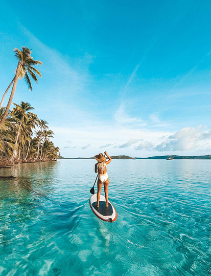Femme faisant du paddle sur une eau turquoise dans les Caraïbes pendant une promotion Black Friday jusqu’à -10% à la Toubana Hôtel & Spa