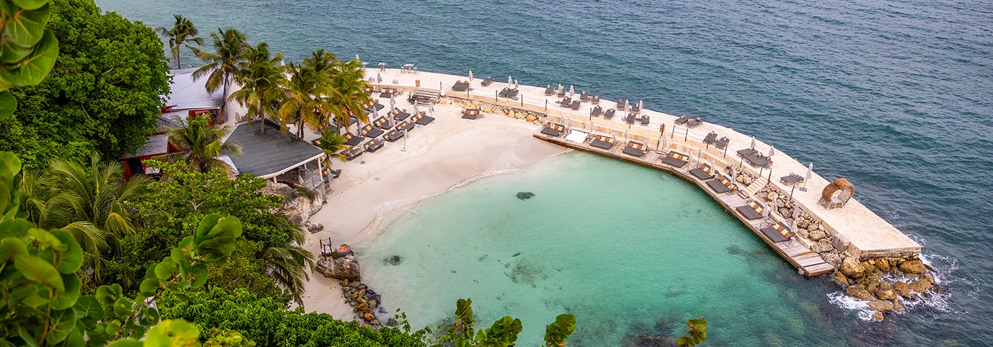 Couple se promenant au bord de la piscine à débordement avec vue mer à La Toubana Hôtel & Spa en Guadeloupe