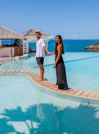 Couple se promenant au bord de la piscine à débordement avec vue mer à La Toubana Hôtel & Spa en Guadeloupe