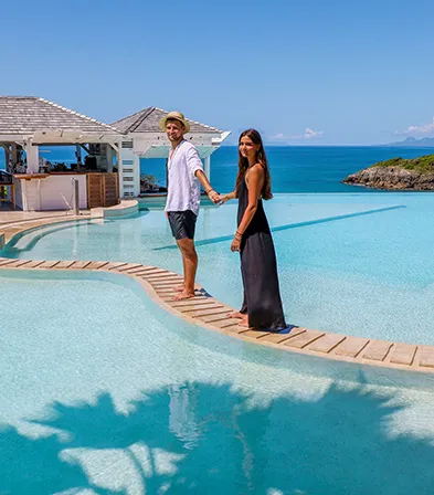 Couple se promenant au bord de la piscine à débordement avec vue mer à La Toubana Hôtel & Spa en Guadeloupe