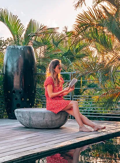 Femme lisant sur une terrasse tropicale à La Toubana Hôtel & Spa en Guadeloupe