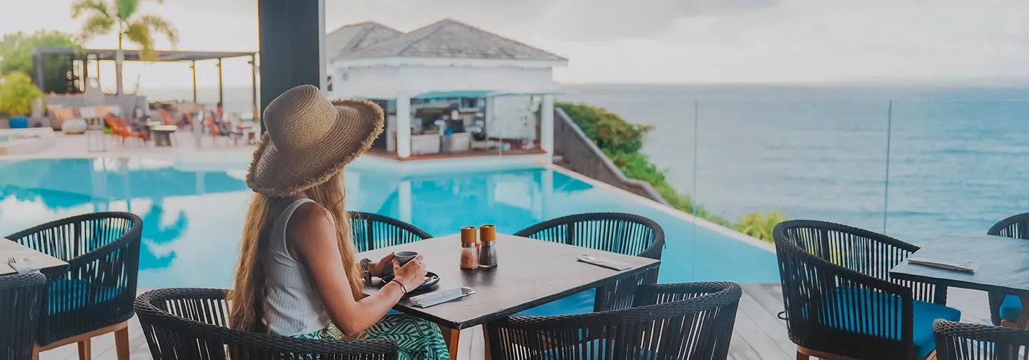 Eine Kundin beim Frühstück auf der Terrasse mit Blick auf den Pool und das Meer im La Toubana Hotel & Spa