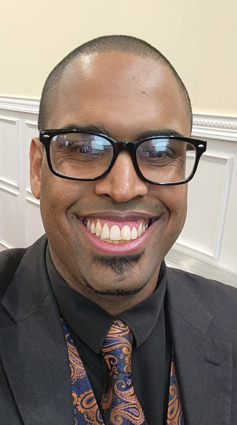 Mr. Anthony Vasquez smiling in suit jacket and paisley tie