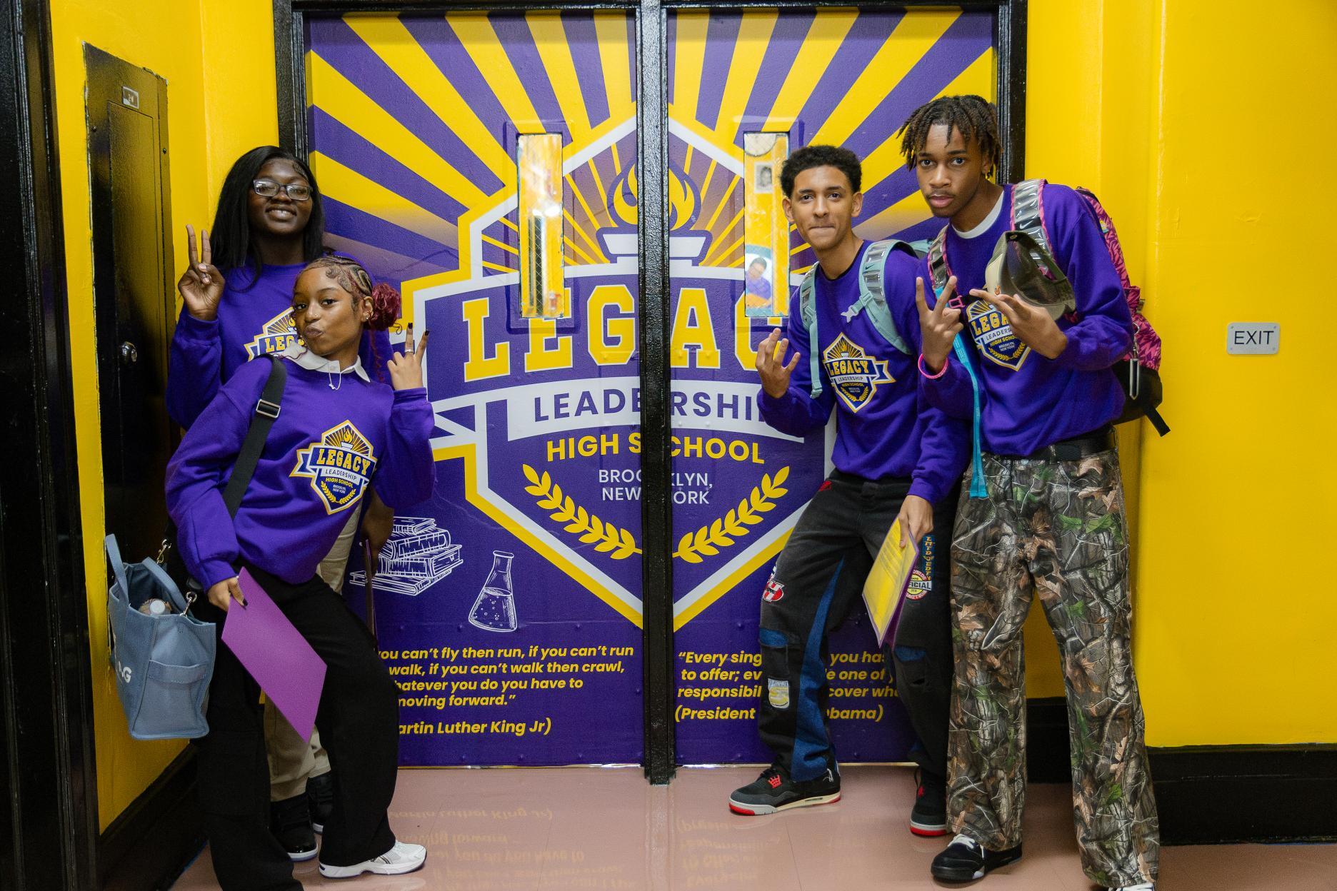 Four Legacy Leadership High School students posing in school hallway