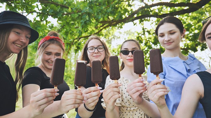 Six yearbook editors say cheers with ice cream bars to celebrate the yearbook being finished.