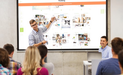 Yearbook student reviewing ladder snad page status with classmates and yearbook adviser
