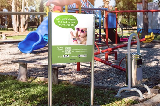 QR code on a yearbook poster in the park is for ease of ordering an elementary yearbook.