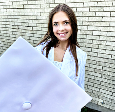 Graduate holding her cap in front to create depth