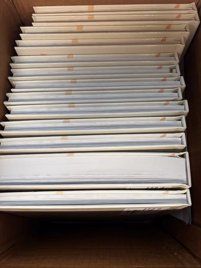 Box of yearbooks with one extra thick book because the parent who purchased added 100 custom pages to celebrate her child.