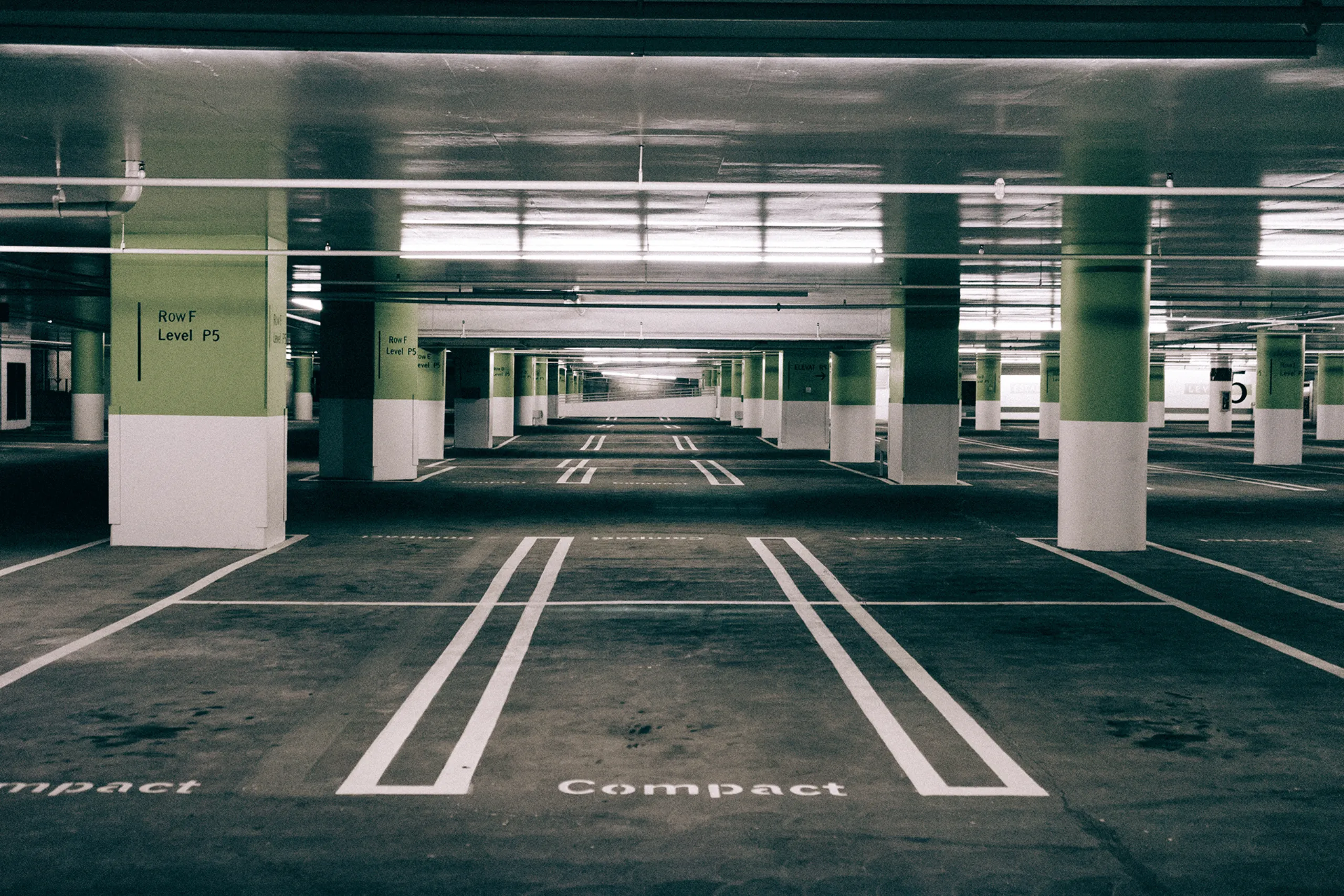 A parking garage with a sign that says Compact.