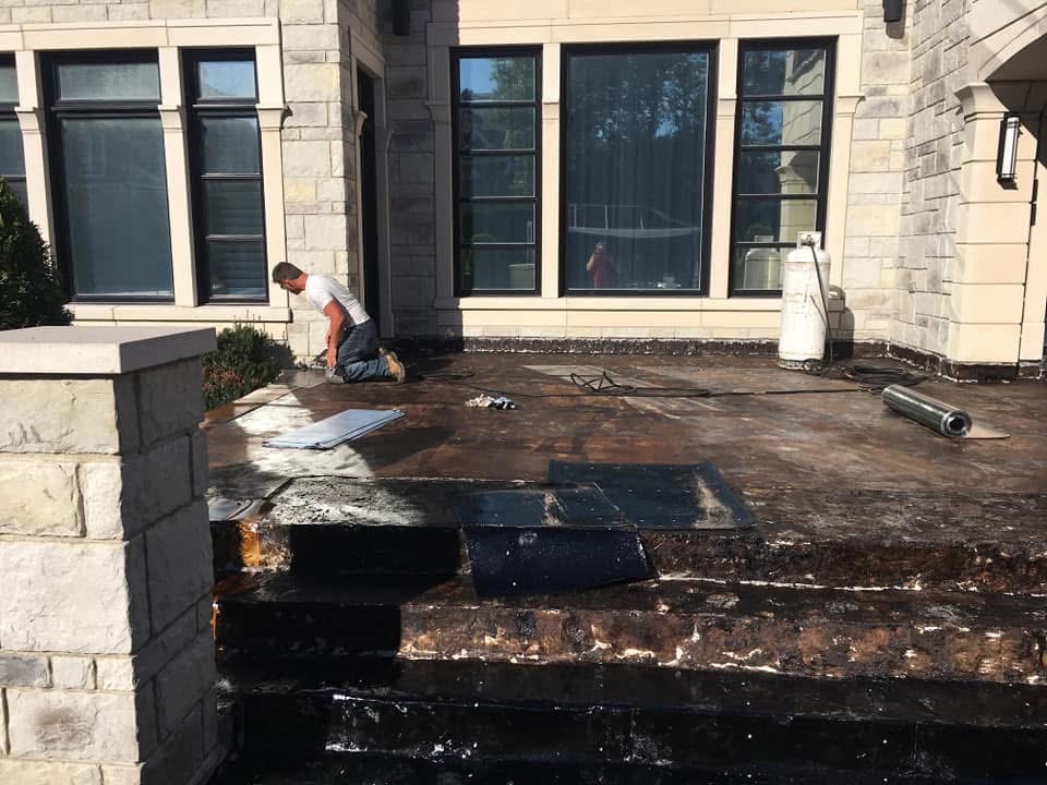 A man is working on a roof of a house.