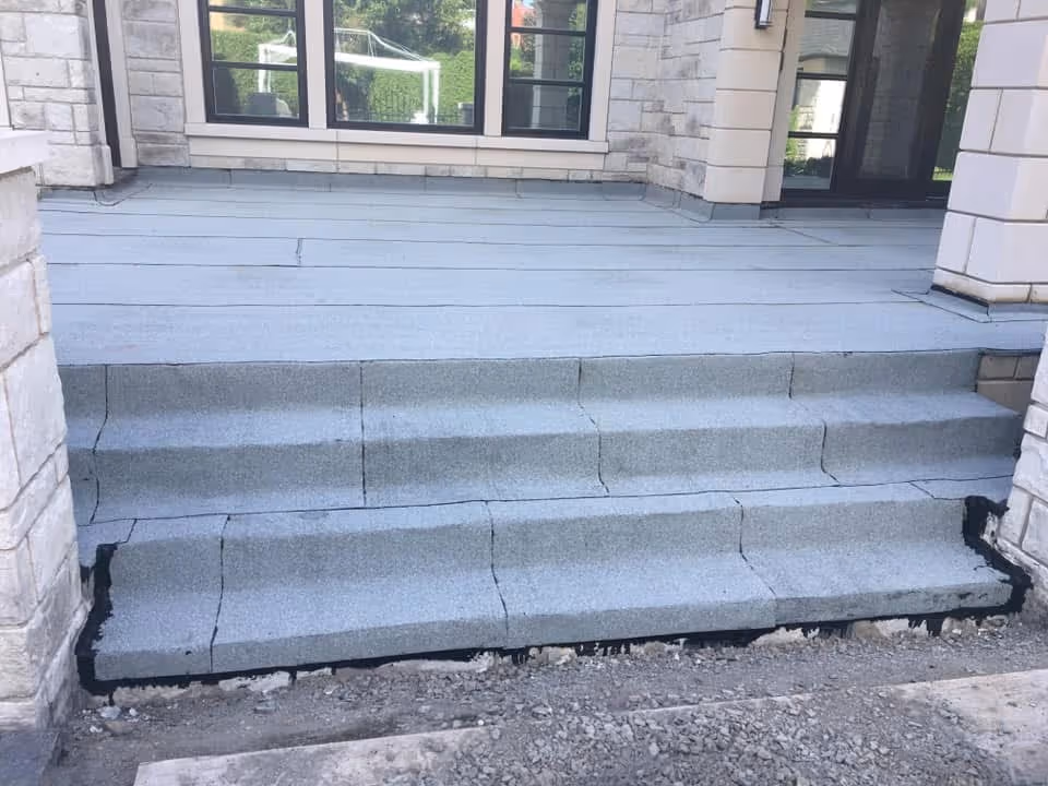 A concrete staircase with a grey tread.