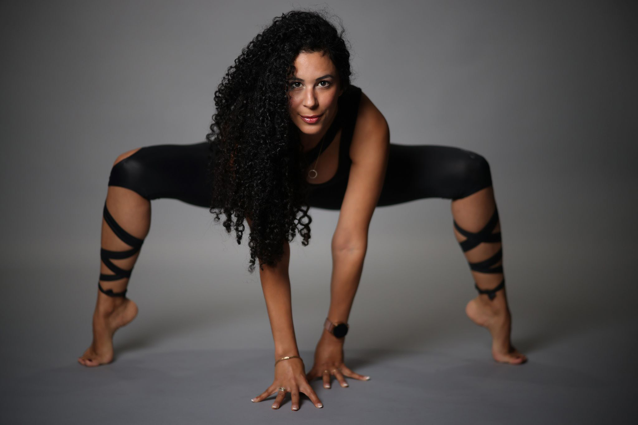 A woman spreading her legs while doing a Pilates exercise