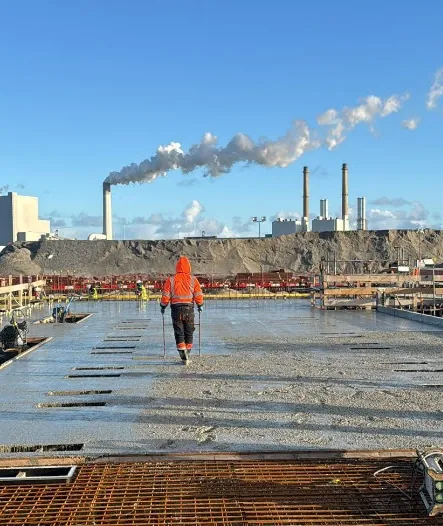Medewerker loopt over groot oppervlak van energietransitie project in aanbouw