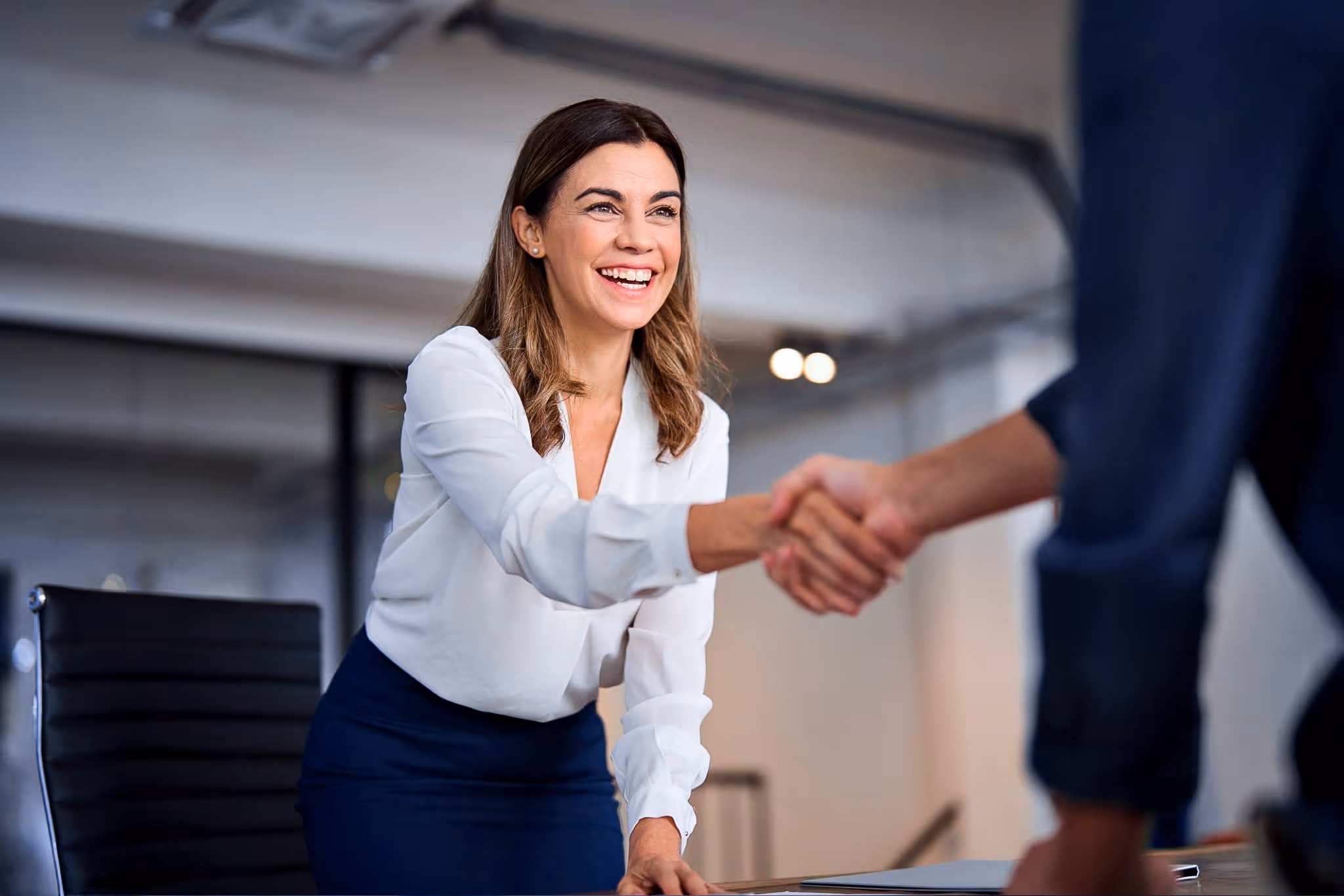A financial planner shaking hands with her client.