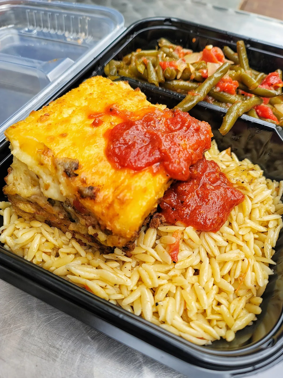 A plate of food with a slice of meat and vegetables.