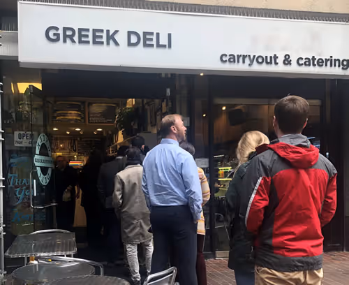 People outside of Greek Deli & Catering waiting to order