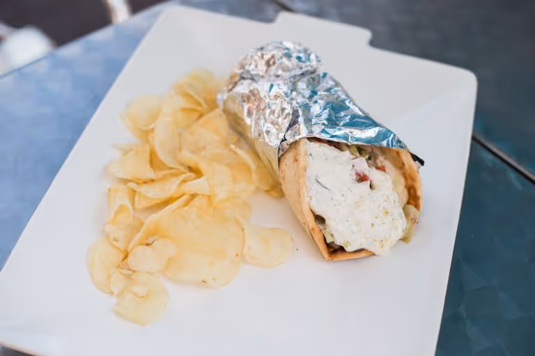 A plate of food with a sandwich and chips.