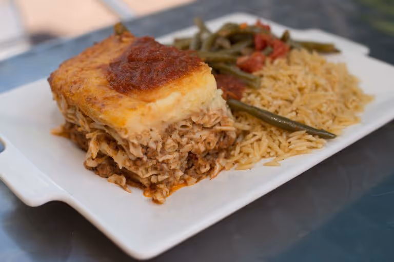 A plate of food with a slice of meat and vegetables.