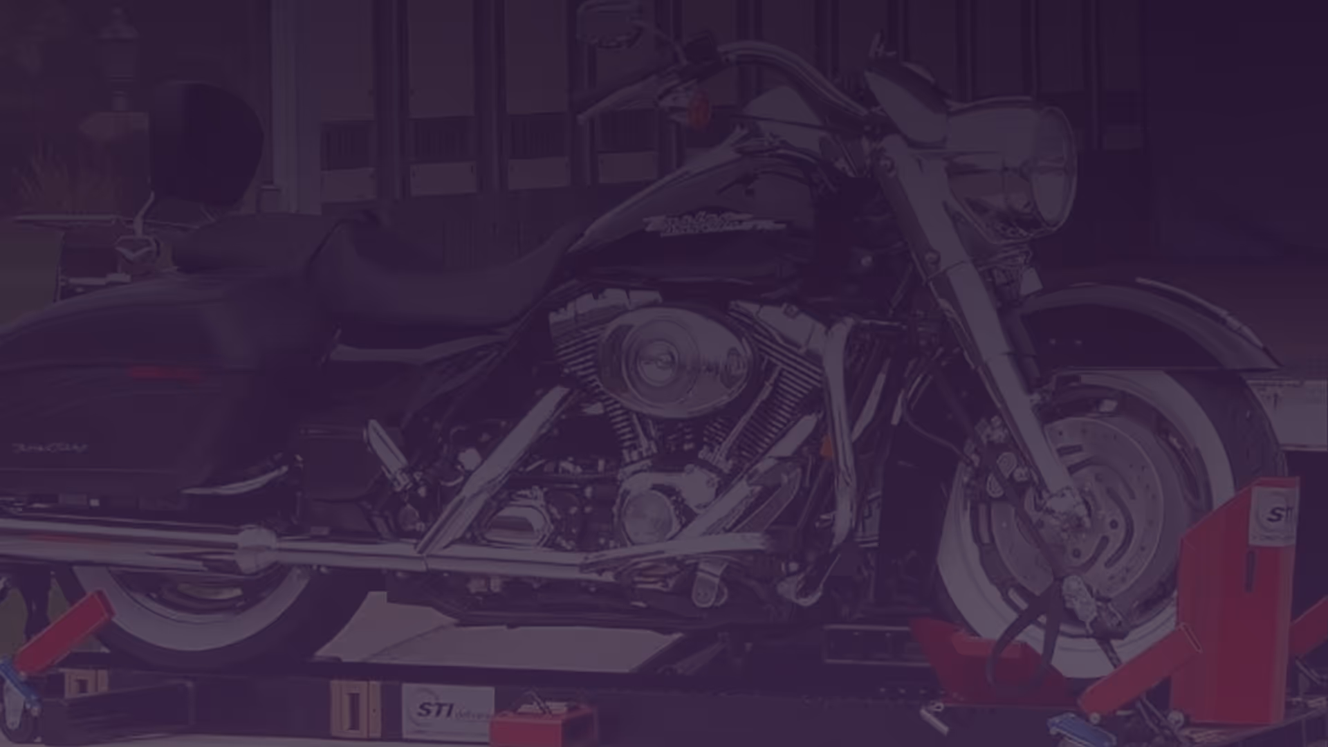 Black Harley-Davidson motorcycle secured on a red and black shipping platform.