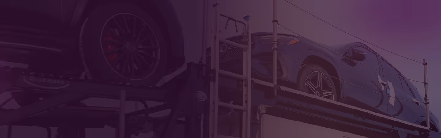Two black luxury SUVs loaded on a multi-level auto transport trailer.