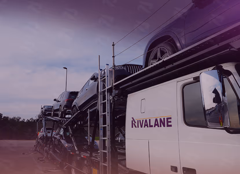 Car carrier truck loaded with multiple SUVs parked outdoors under a cloudy sky.