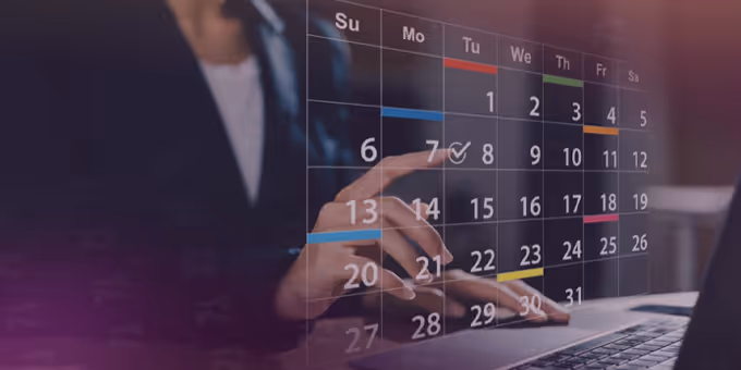 Person interacting with a virtual calendar overlay showing a monthly view with highlighted dates above a laptop keyboard.