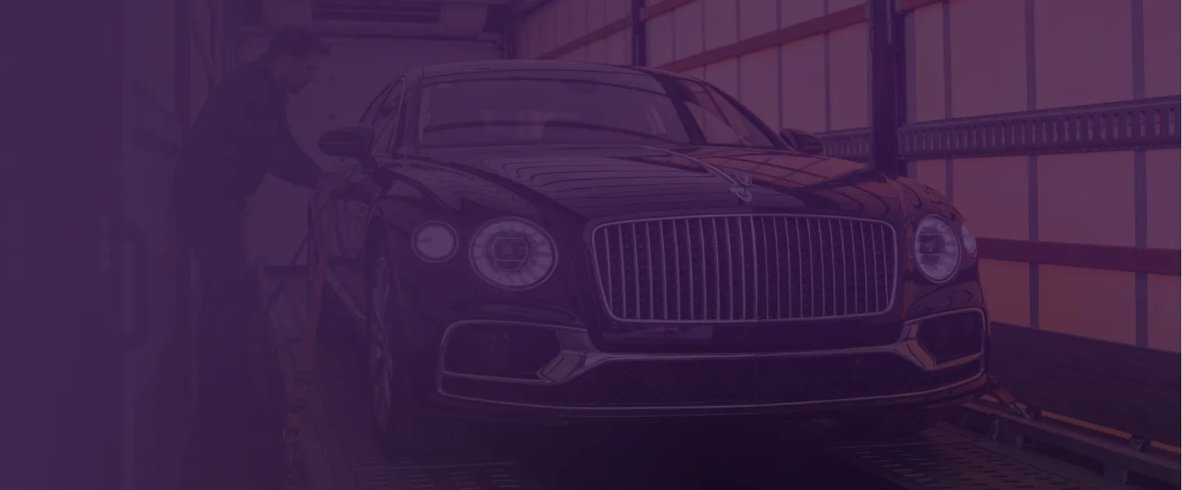 Close-up of a luxury vehicle's front grille and headlights, representing Rivalane's White Glove auto transport service