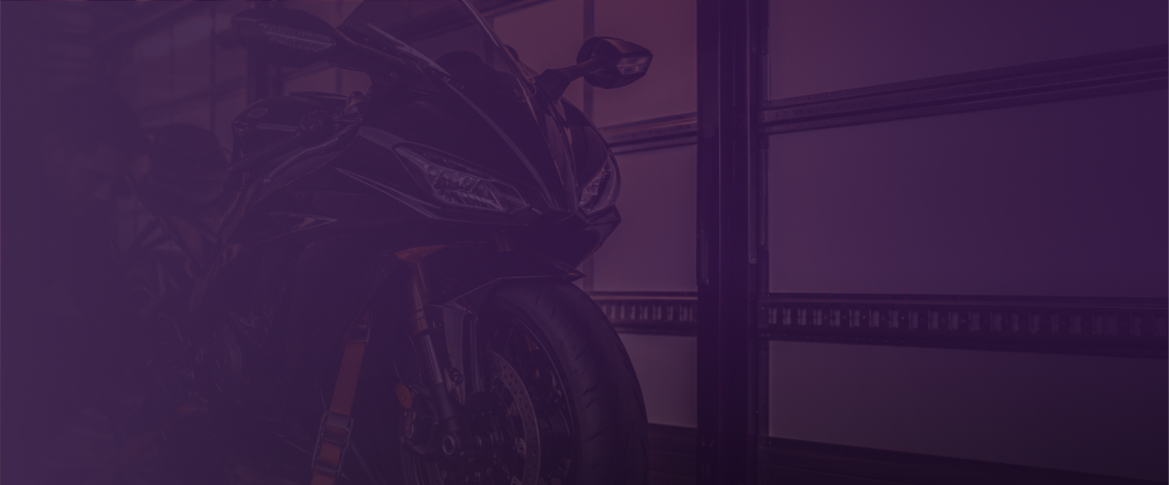Motorcycle parked in an indoor garage setting, background image for the motorcycle transport service page.