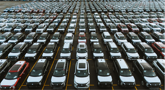 Aerial view of cars parked in neat rows at an outdoor vehicle storage lot