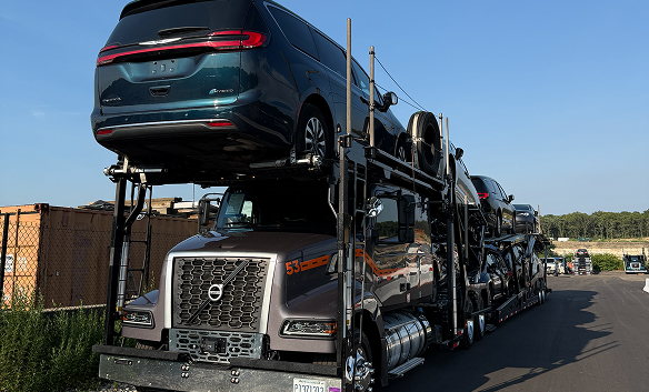 Multi-car carrier hauling SUVs collected from an auction lot.