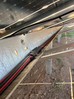 The image shows a solar panel with wiring and a label indicating it is a Roon ACCT BURTAL GOCT CIRI DEC C224041, manufactured in the USA.AI-generated content may be incorrect.