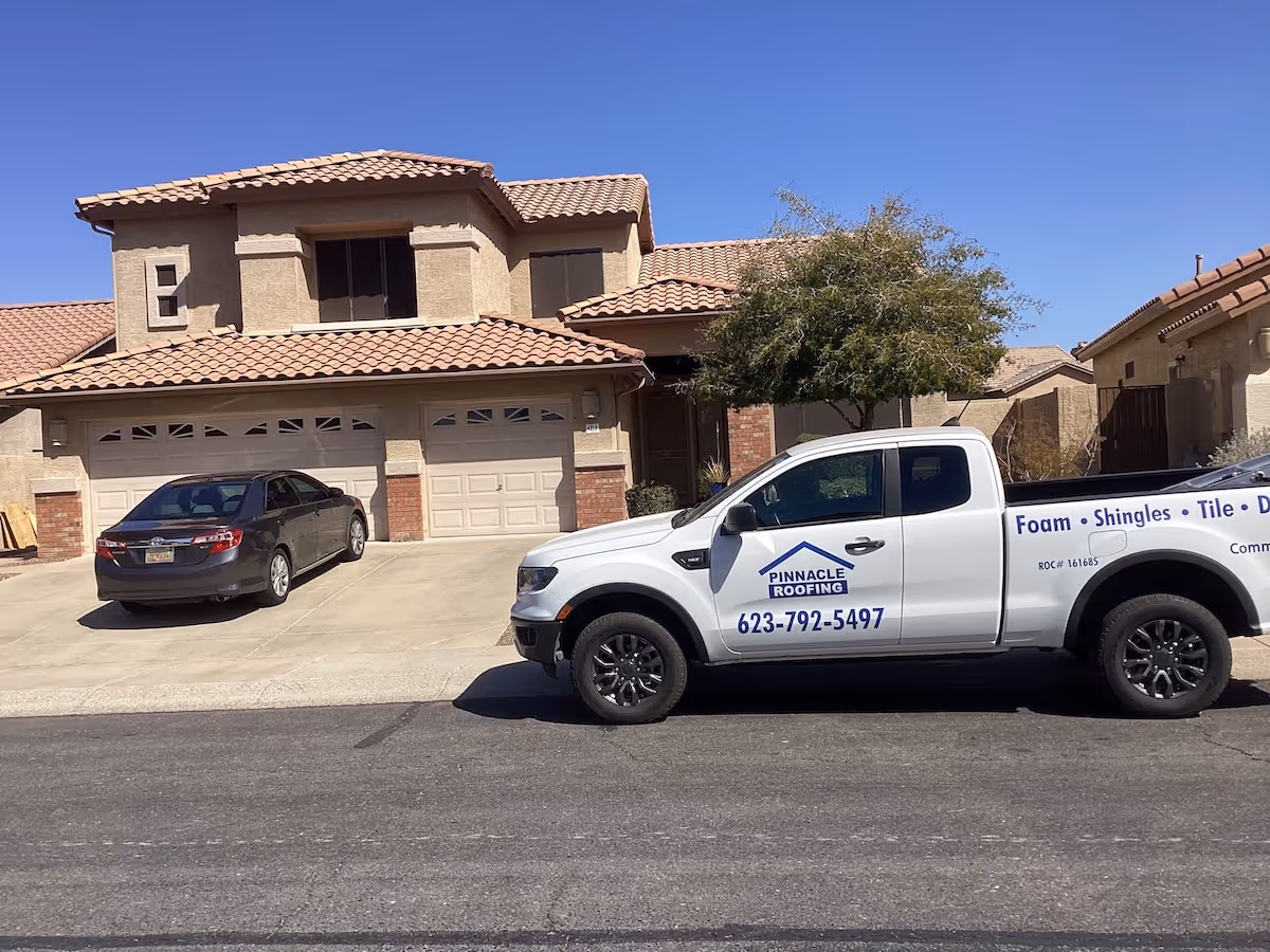 a Pinnacle Roofing service truck in front of a Phoenix home with a tile roof